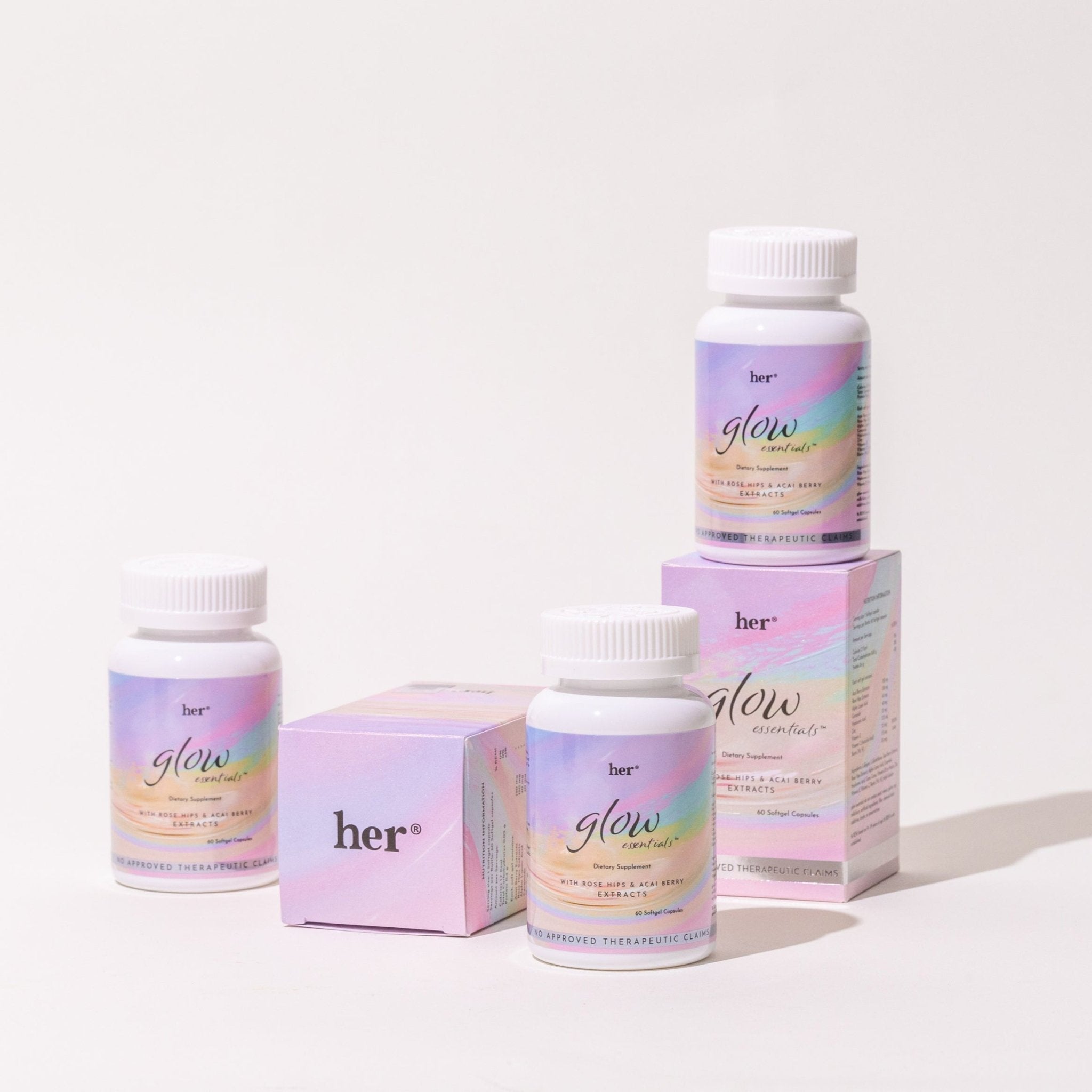 A stack of several HER® Glow Essentials® supplement bottles, suggesting a full routine or subscription for long-term foundational health and skincare from within.