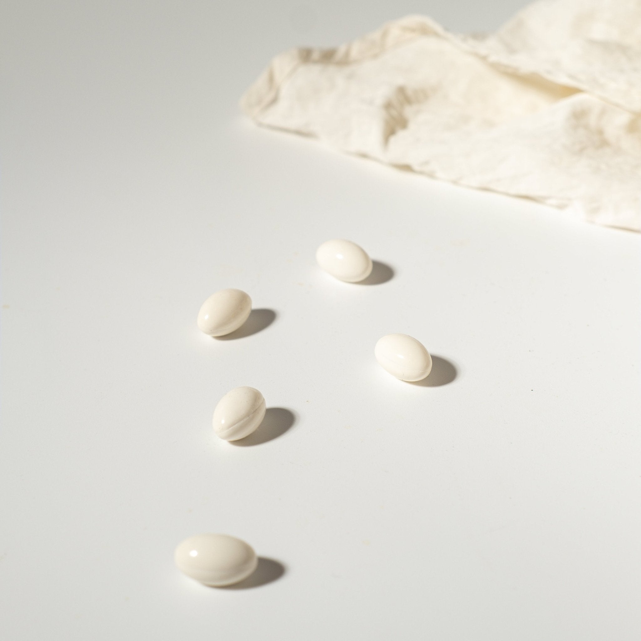  HER® Glow Essentials® capsules, illuminated to show its vibrant color, representing the precisely measured dosage and high potency of our science-backed formula.