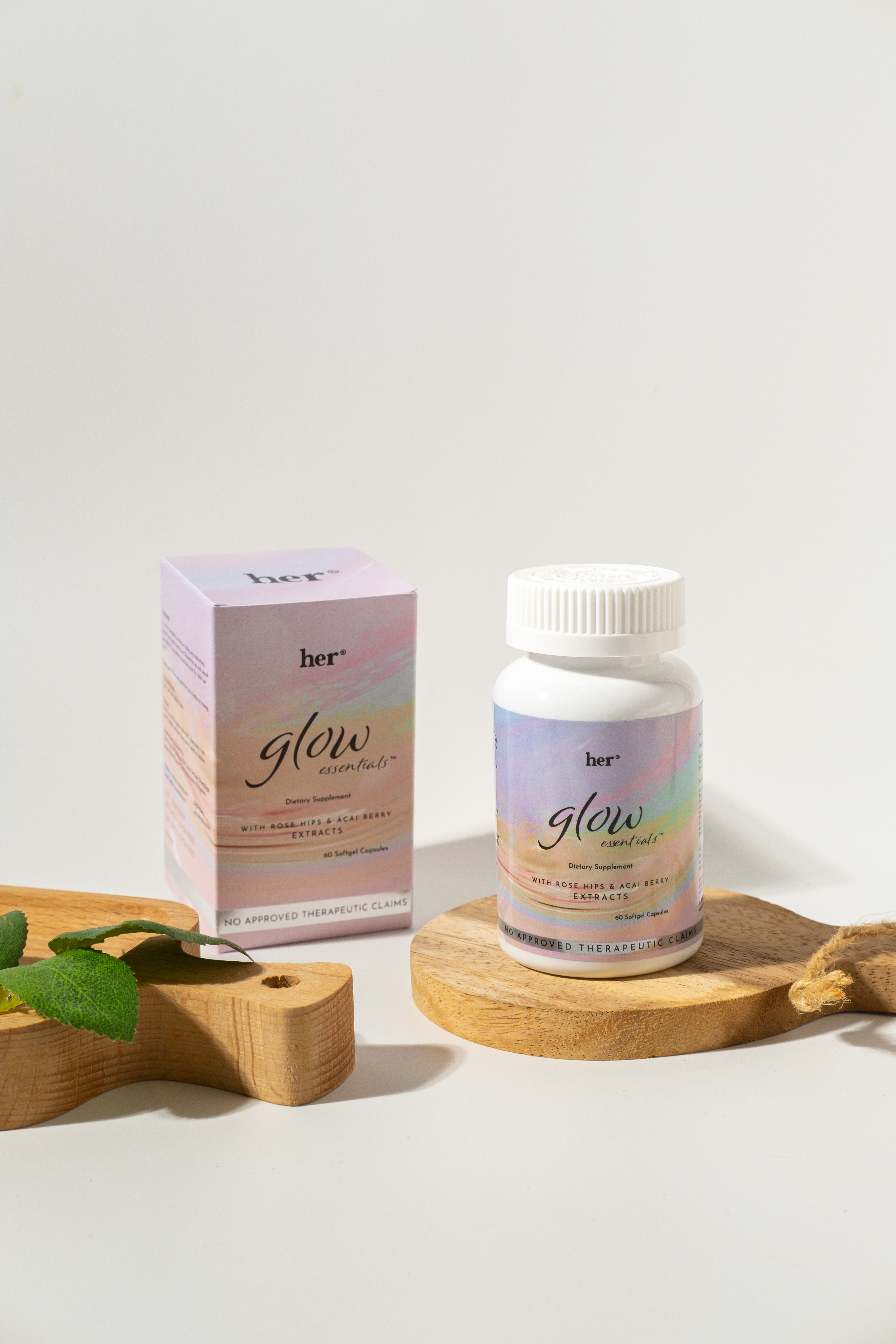 Supplement bottle and packaging labeled 'her glow' on a light background
